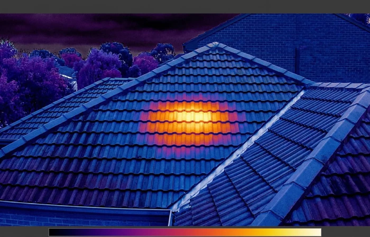 A radiometric thermal image of a roof section rendered in the ironbow colour scale, a warmer patch standing out clearly against the dry surrounding covering